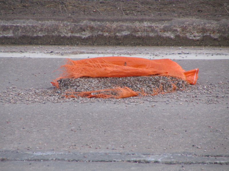 split gravel bag on road