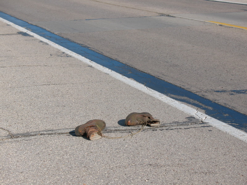 old work boots in road