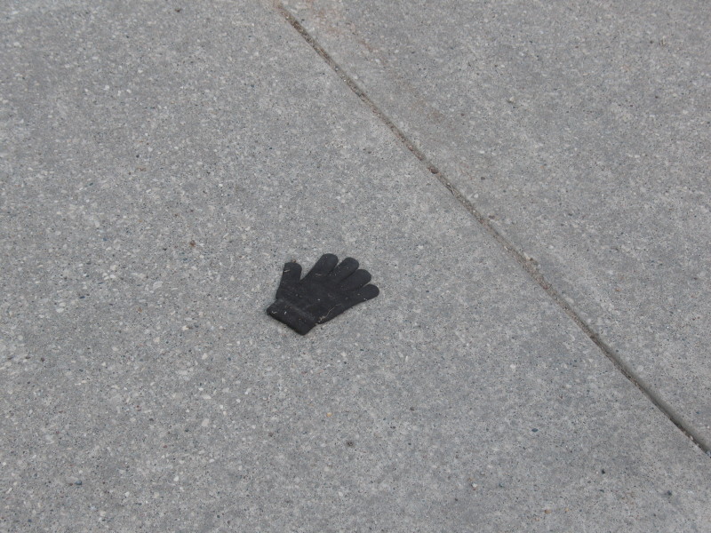 small black glove in road