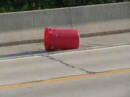 bright garbage can in road